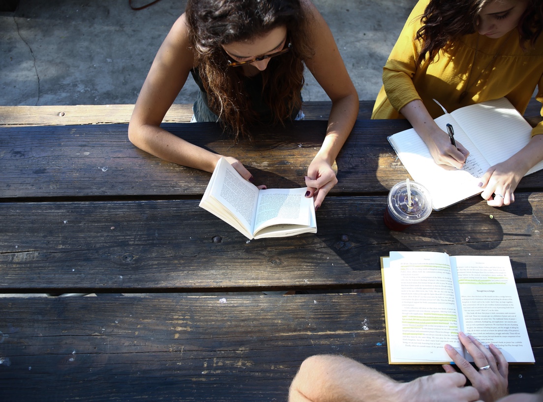 Students studying at a picnic table.