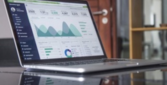 Laptop displaying graphs on table