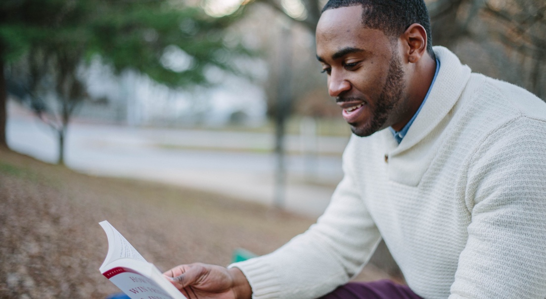 Man reading a book outdoors